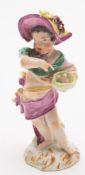 An 18th century German porcelain figure of a putto emblematic of Summer: holding a bird's nest with