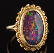 An oval opal triplet single-stone ring:, the shank stamped '18K', 6.5gms gross weight.
