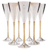 Seven Elizabeth II silver and gilt champagne flutes, maker Stuart Devlin, London, 1977, 1978,