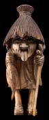 A amusing Japanese wood and ivory okimono of Karakasa kozo: the mythical figure wearing a large