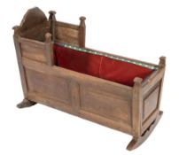 A 17th century oak cradle:, of tapering form with fielded panel sides on curved sleigh supports,
