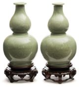 A pair of Chinese celadon glazed double gourd vases: each impressed with phoenix medallions,