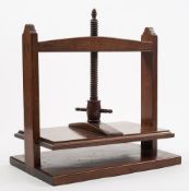 A 19th century mahogany table-top flower press: the central worm carved with an acorn finial over a