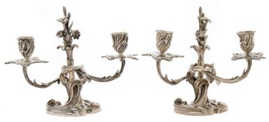 A matched pair of Continental cast silver twin-branch candelabra: one bearing French marks,