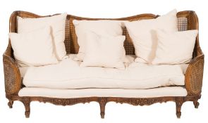 A Continental carved beechwood bergere settee:, of rectangular shaped outline,