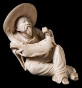 A carved ivory figure of Jiang Ziya: seated wearing a broad hat and holding a large fish, signed,