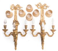 A pair of Louis XV-style giltwood and gesso three-branch wall lights: each ribbon tied and fluted