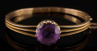 A gold and amethyst single-stone hinged bangle: the circular amethyst 15.