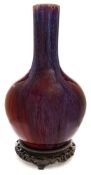 A Chinese flambe-glazed bottle vase: the globular body and cylindrical neck covered with a mottled