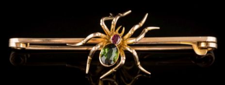 A 15ct gold, green gem and ruby-set 'spider' bar brooch:, 62mm total length, 7gms gross weight.