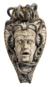 A carved stone corbel of Medusa : entwined with lead snakes, 55cm. high.