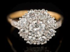 An 18ct gold and diamond mounted circular cluster ring: with central round brilliant-cut diamond 6.
