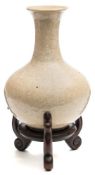A Chinese crackle-glazed bottle vase: of pale celadon colour, 26 cm high and wood stand.