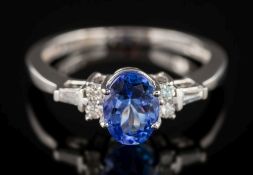 An 18ct white gold, tanzanite and diamond ring: the central, oval tanzanite approximately 1.