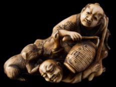 A Japanese carved ivory okimono, signed Hojitsu: depicting two drunken men,