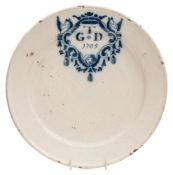 An early 18th century dated delftware marriage plate: painted in blue with a 'merryman' style