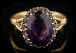 An 18ct gold, amethyst and diamond oval cluster ring: 11.9mm long x 8.