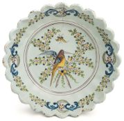 A French faience dish: of circular fluted form with scalloped rim painted in green, yellow,