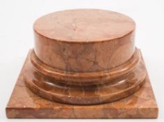 An orange and variegated orange marble statue base: the circular short column on a square plinth,