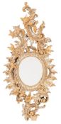 A 19th Century Continental carved gilt and silvered wood wall mirror:, of shaped outline,