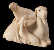 A Japanese ivory netsuke and one other: the first carved as a family of goats with ebony eyes,