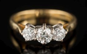 An 18ct gold and diamond three-stone ring: with circular,