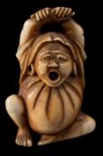 A Japanese carved ivory netsuke, signed Masatoshi: of Daruma yawning and stretching,