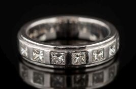 A modern 18ct white gold and princess-cut diamond seven-stone ring: in rub over setting,