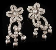 A pair of diamond mounted floral cluster pendant earrings: each with a five petal cluster