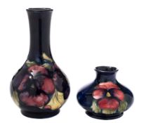 Two Moorcroft pottery vases: tubelined in red, green, purple and blue in the Pansy pattern,