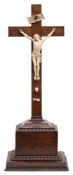 A rosewood and ivory crucifix: the carved ivory figure of Christ with 'INRI' titlus above and skull