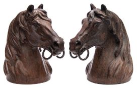 A pair of cast iron and bronze patinated busts: of horses' heads, each wearing a bit, unsigned 25.