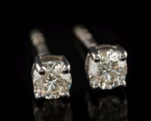 A pair of 9ct white gold and diamond single-stone ear studs: each with a circular,