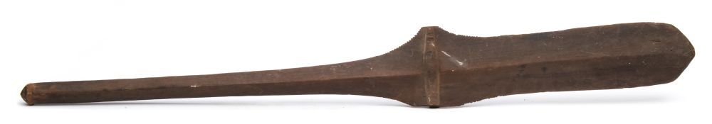 A Fijian paddle headed wood club: with partially serrated edge on a tapering shaft and pommel end,