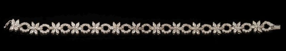An 18ct white gold and diamond encrusted bracelet: with baguette-cut diamond floral design links