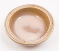 A Chinese porcelain brush washer of Jun type: of shallow circular form under buff and milky pink