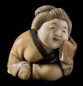 A Japanese carved, stained and inlaid ivory netsuke, signed Hosei: of a seated smiling woman,