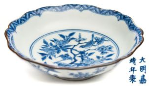 A small Chinese porcelain dish: of petal shaped form the centre painted in blue with a circular