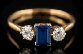 An 18ct gold, sapphire and diamond three-stone ring: the rectangular sapphire 6mm long x 4.