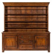 An early 19th Century pine dresser:, the shelved superstructure with a moulded cornice,