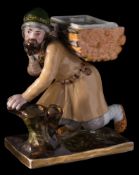 A Gardner (Moscow) porcelain desk stand: in the form of a peasant kneeling by a hollow stump