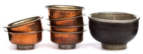 A set of six Tibetan copper tea bowls: with white metal linings and one larger wood and white metal