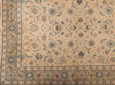 A Tabriz carpet:, the beige arabesque field with an all over design of palmettes,
