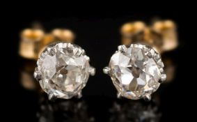 A pair of diamond single-stone ear studs: each with an irregular cushion-shaped old brilliant-cut