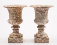 A pair of variegated marble urns: of neo-classical outline, with flared rims and waisted sides,