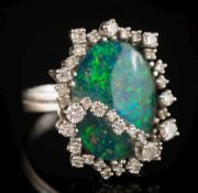 A black opal doublet and diamond oval cluster ring: the oval black opal approximately 19.