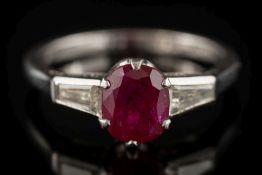 A platinum, ruby and diamond ring: the oval ruby 6.9mm long x 5.7mm wide x 3.