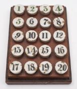 A set of early 20th century ceramic gaming counters numbered 1-20 in a wooden plinth:, 12.