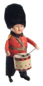 A Schuco tinplate clockwork Guardsman drummer:, black moquette busby and felt uniform,