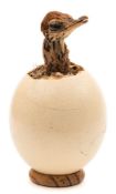 A preserved baby Emu head set in an emu egg under a glass dome:, (no base to dome) 26cm high.